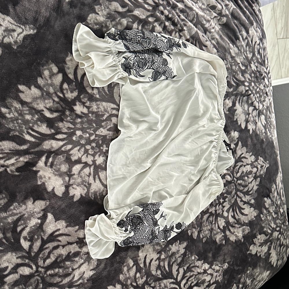White House Black Market Ivory Top with blue floral embroidery on the sleeves
